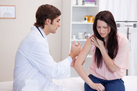 Young male doctor giving patient an injection