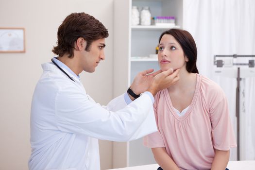 Male doctor examining his patients jaw