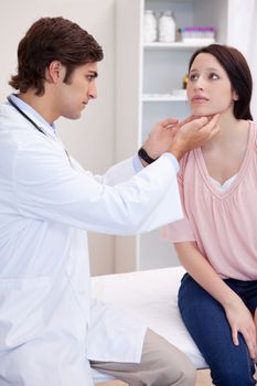 Male doctor examining his female patients jaw