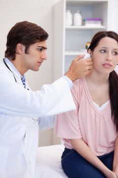 Male doctor examining his patients ear