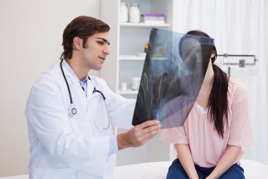 Male doctor analyzing x-ray with his patient