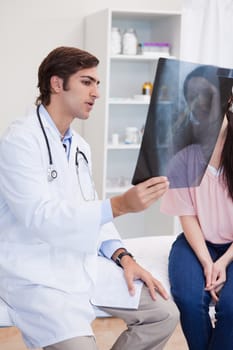 Male doctor analyzing x-ray with his female patient