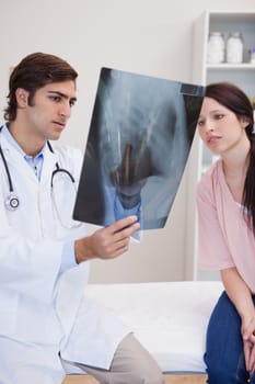 Young doctor and patient looking at x-ray together