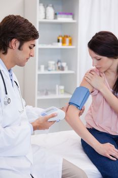 Male doctor analyzing patients blood pressure