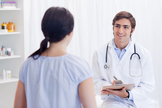 Smiling young physician talking with patient