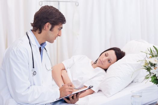 Young doctor talking to his patient that just woke up