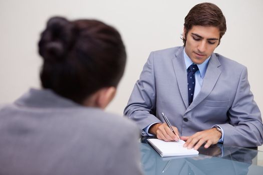Young businessman in meeting taking notes