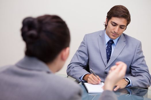 Young businessman in negotiation taking notes