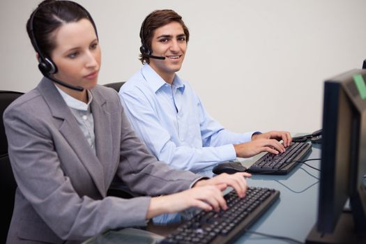 Side view of young call center agents working in their office