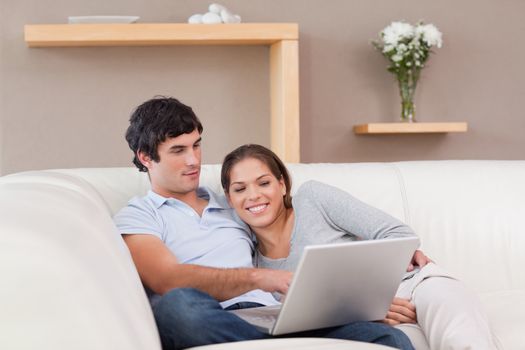 Young couple with their laptop on the couch