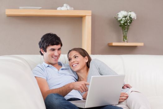 Young couple with their notebook on the sofa