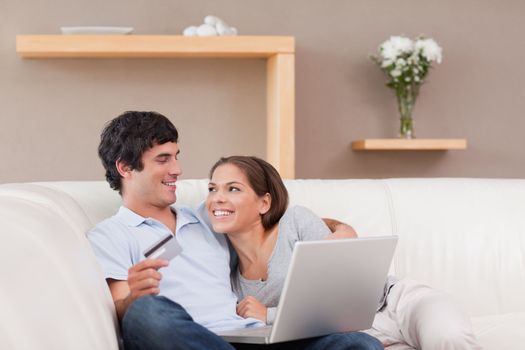 Cheerful young couple booking holiday online