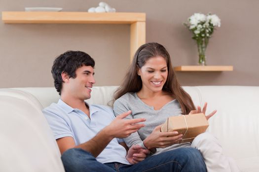 Young couple on the sofa with parcel