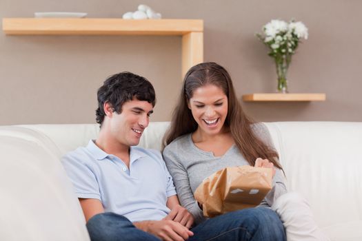 Young couple on the couch with parcel