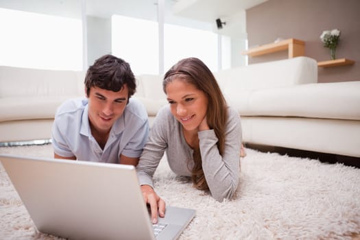 Young couple with laptop on the floor