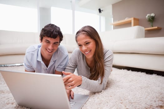 Young couple with notebook on the floor