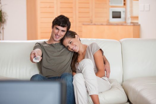 Young couple on the couch watching television together