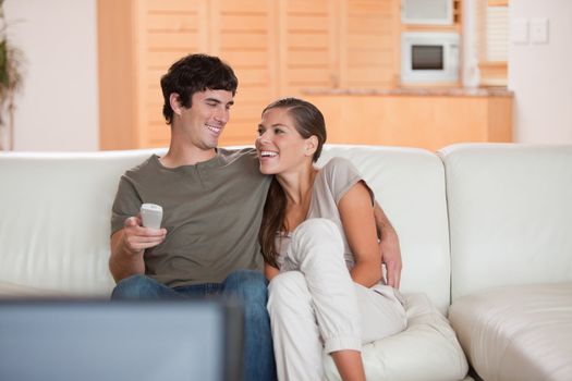 Laughing young couple watching funny movie together