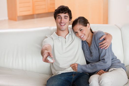Young couple watching television on the sofa