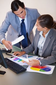 Young businesswoman talking with her colleague about statistics