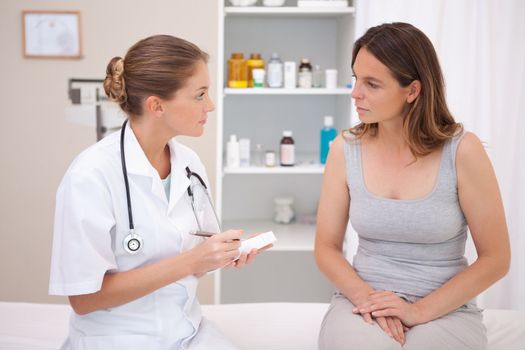 Doctor taking notes while patient is talking
