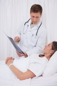 Doctor explaining x-ray to bedridden patient
