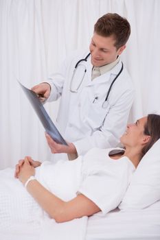 Doctor showing x-ray to his bedridden patient