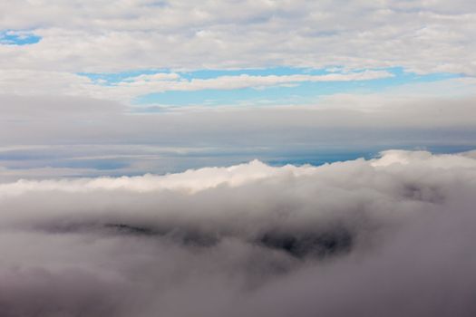 Among fluffy clouds billowing forming a cloudscape in the sky