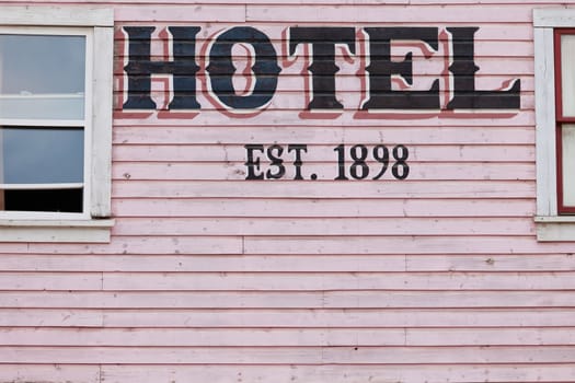 Detail of painted pink historic hotel wooden facade siding