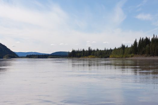 Boreal forest hills at river bank of Yukon River, Yukon Territory, Canada, near Dawson City forming a beautiful northern riverscape.