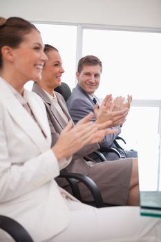 Side view of business team applauding after a presentation