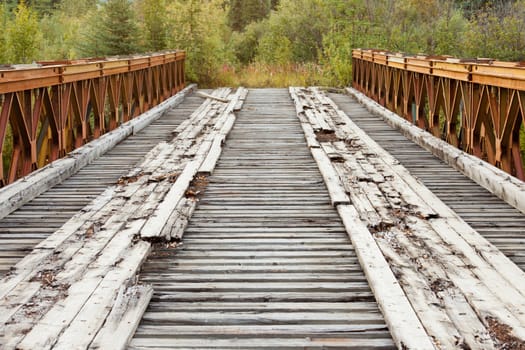 Old rotten abandoned steel and wood bridge leading to nowhere