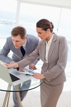 Analyst explaining report on laptop to her boss