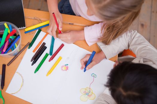 Above view of little schoolgirls drawing in a classroom