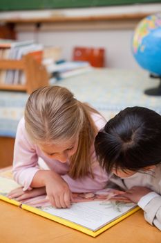 Portrait of focused schoolgirls reading a fairy tale in a classroom