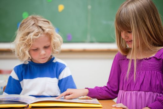 Pupils reading a book in a classroom