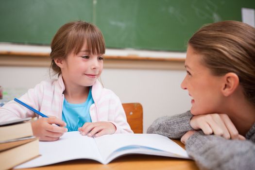 A teacher and a schoolgirl talking in a classroom