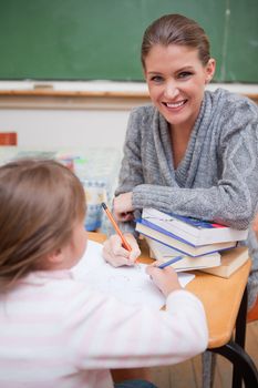 Portrait of a teacher explaining something to her pupil in a classroom