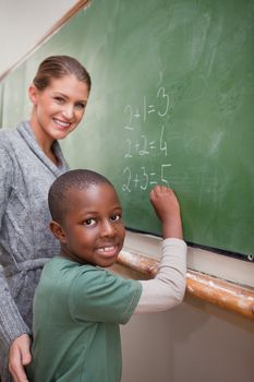 Portrait of a teacher explaining mathematics to a pupil on a blackboard