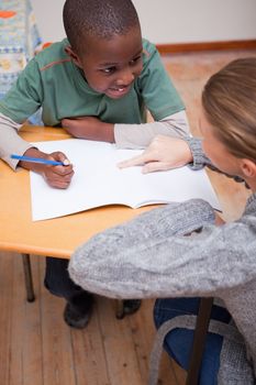 Portrait of a teacher explaining something to a schoolboy in a classroom