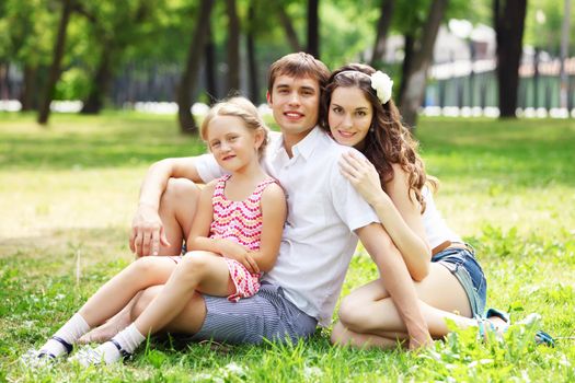 Young Family Outdoors on the grass in Park in summer