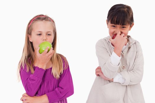 Girls eating apples against a white background
