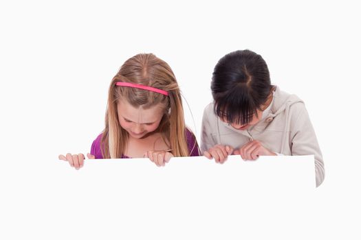 Girls looking at a blank panel against a white background