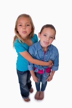 Portrait of girls sticking out their tongues against a white background