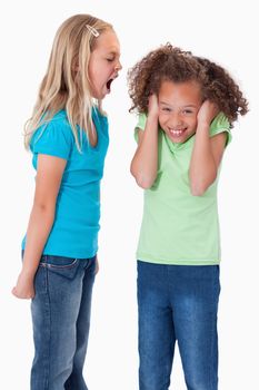 Portrait of an angry girl screaming at her friend against a white background