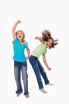 Portrait of cheerful girls jumping against a white background