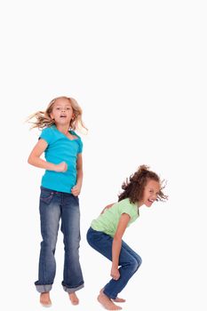 Portrait of happy girls jumping against a white background