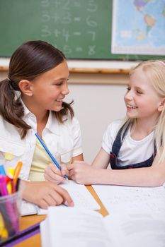 Portrait of happy pupils working together on an assignment in a classroom