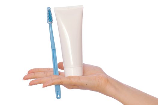 Tooth-paste and brush at in the girl's hand
