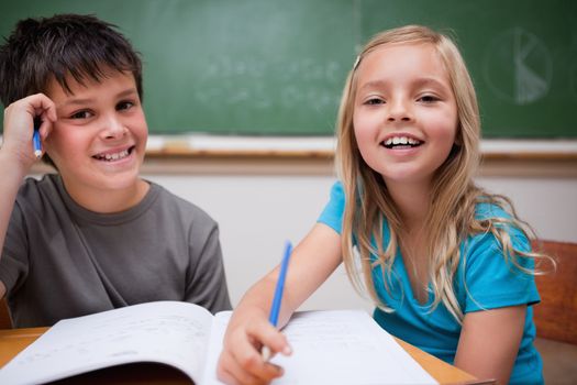Two children writing in a classroom